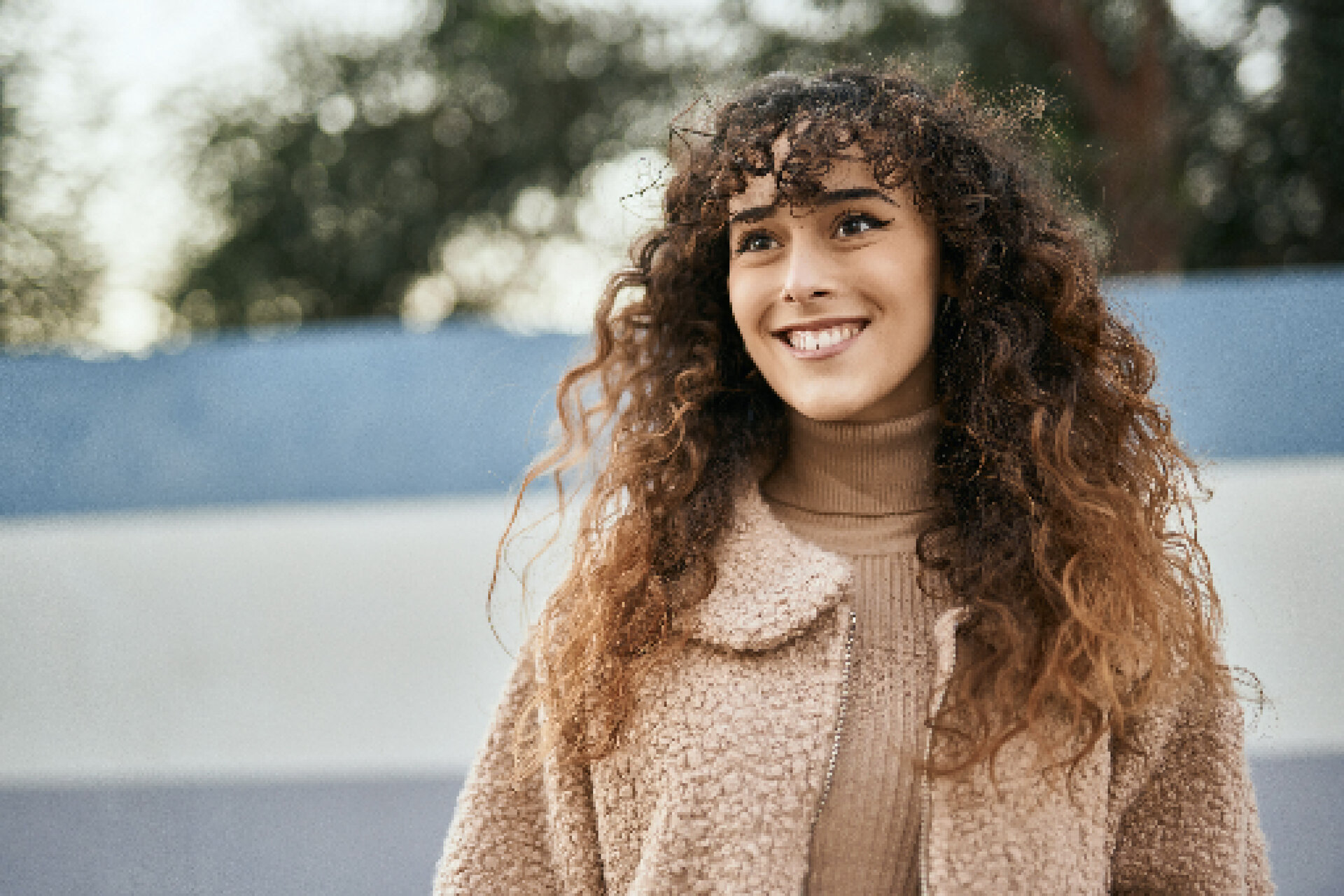 rsz_1young-hispanic-woman-smiling-happy-standing-city young woman with wavy hair smiling